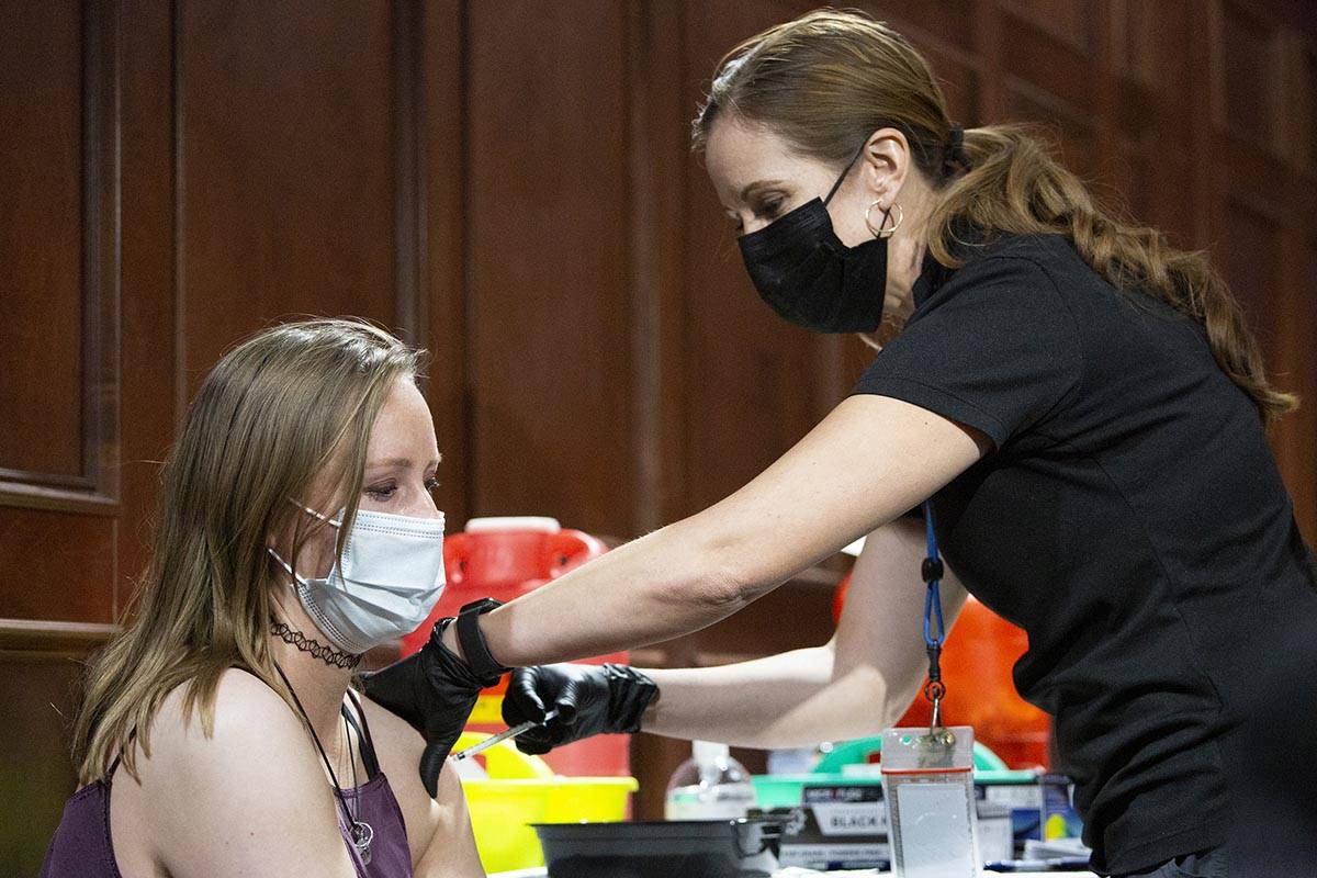 Savannah Wilkinson receives the Pfizer vaccine from Sarah Lugo, senior community health nurse w ...