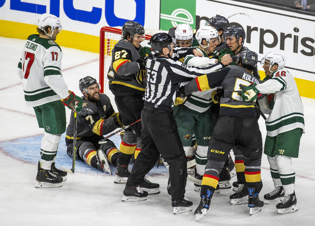 Golden Knights and Minnesota Wild players fight near the net during the third period of an NHL ...