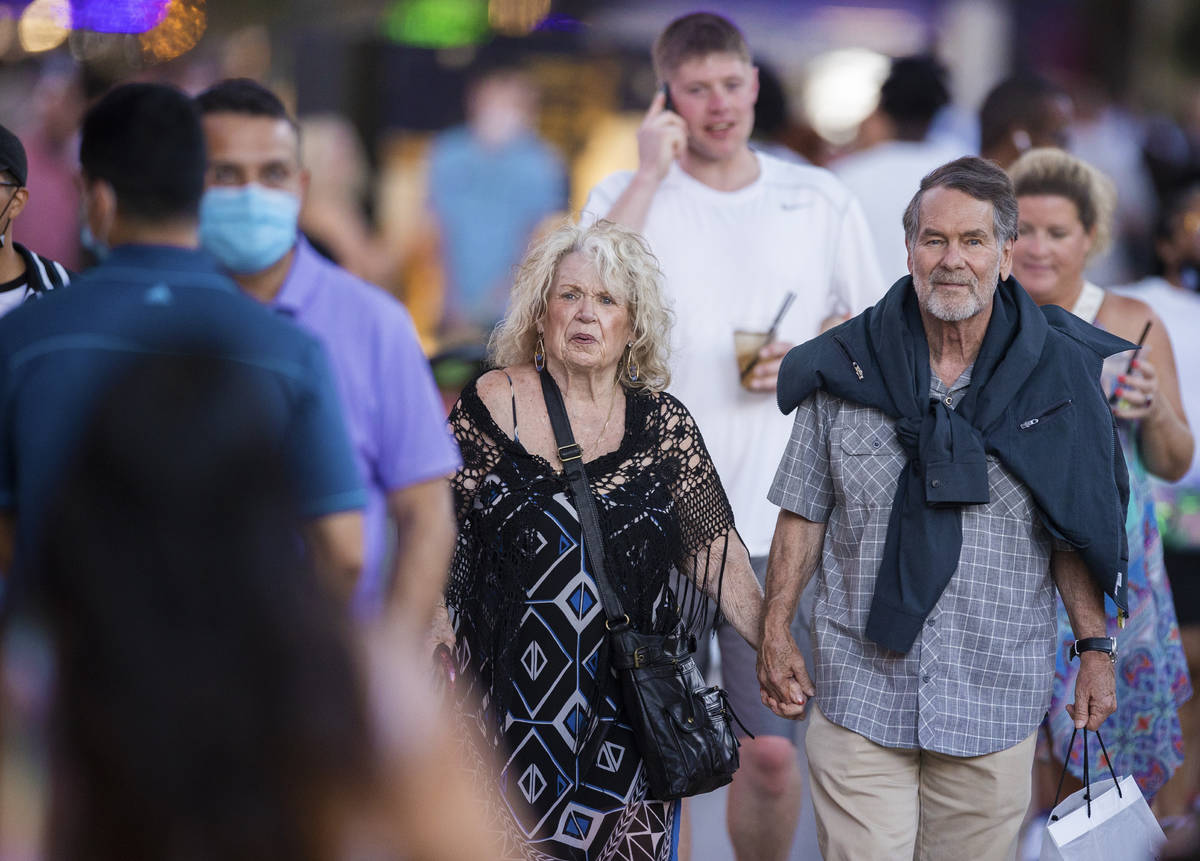 Maskless people walk through the Fremont Street Experience on Thursday, May 13, 2021, in Las Ve ...
