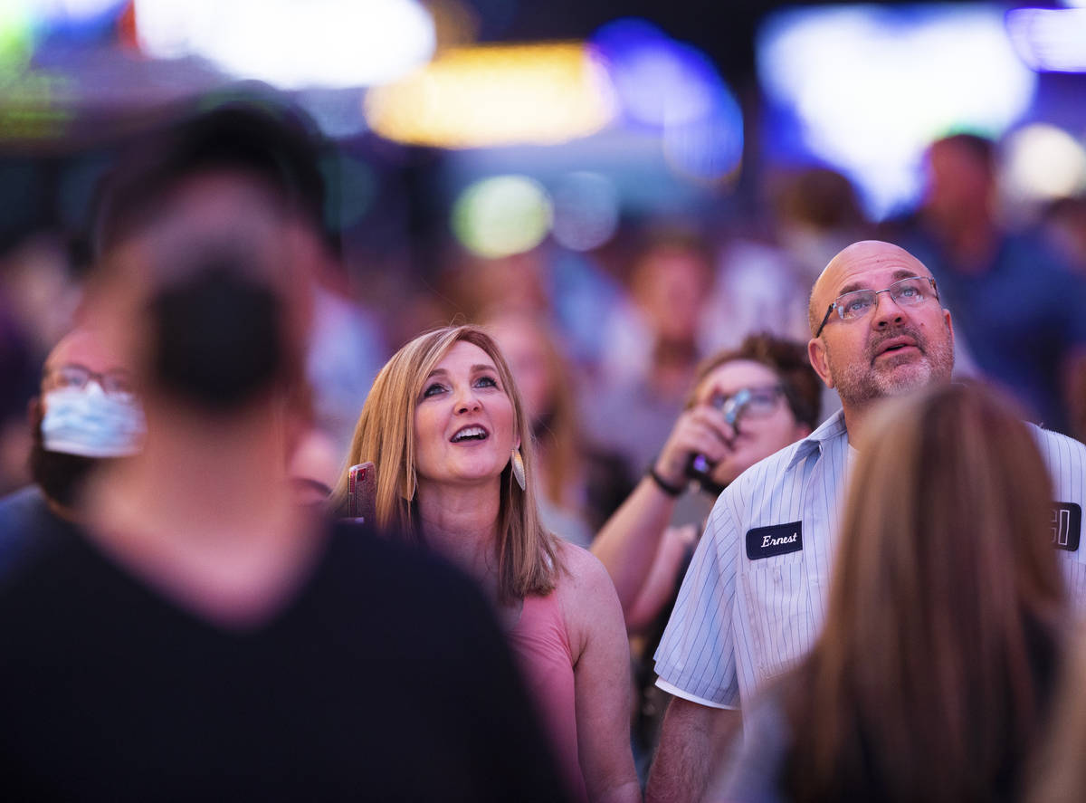 Maskless people walk through the Fremont Street Experience on Thursday, May 13, 2021, in Las Ve ...