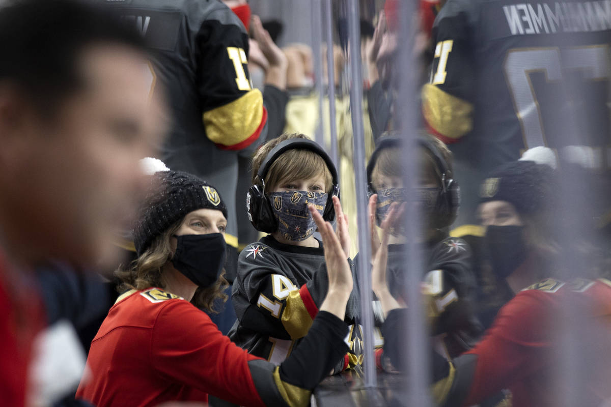 Golden Knights fans clap on the glass before an NHL playoff game between the Golden Knights and ...