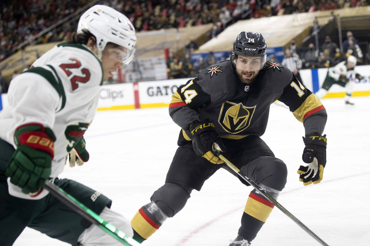 Golden Knights defenseman Nicolas Hague (14) and Wild left wing Kevin Fiala (22) compete for th ...