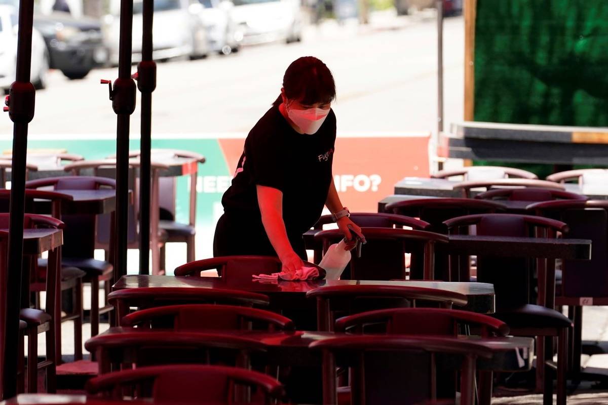 Tables are cleaned in an outdoor eating area amid the COVID-19 pandemic Tuesday, May 18, 2021, ...