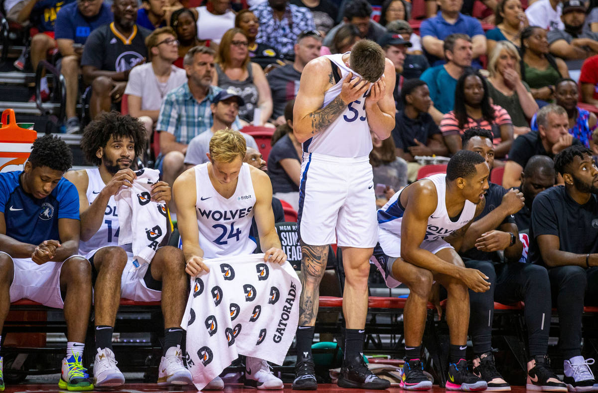 Minnesota Timberwolves forward Mitchell Creek wipes his eyes while standing  beside his teammate …