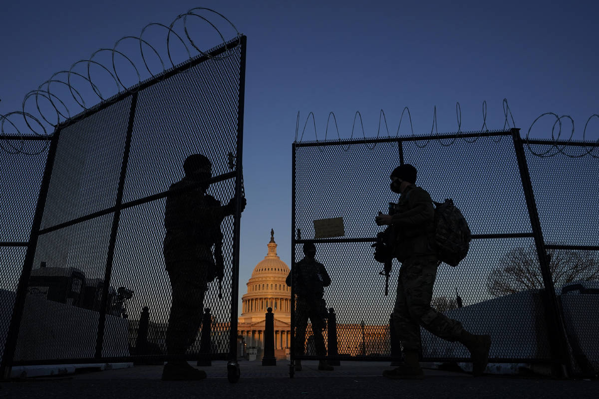 FILE - In this March 8, 2021, file photo, members of the National Guard open a gate in the razo ...