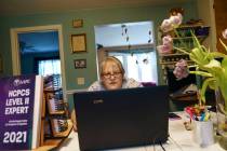 Ellen Booth, 57, studies at her kitchen table to become a certified medical coder, in Coventry, ...