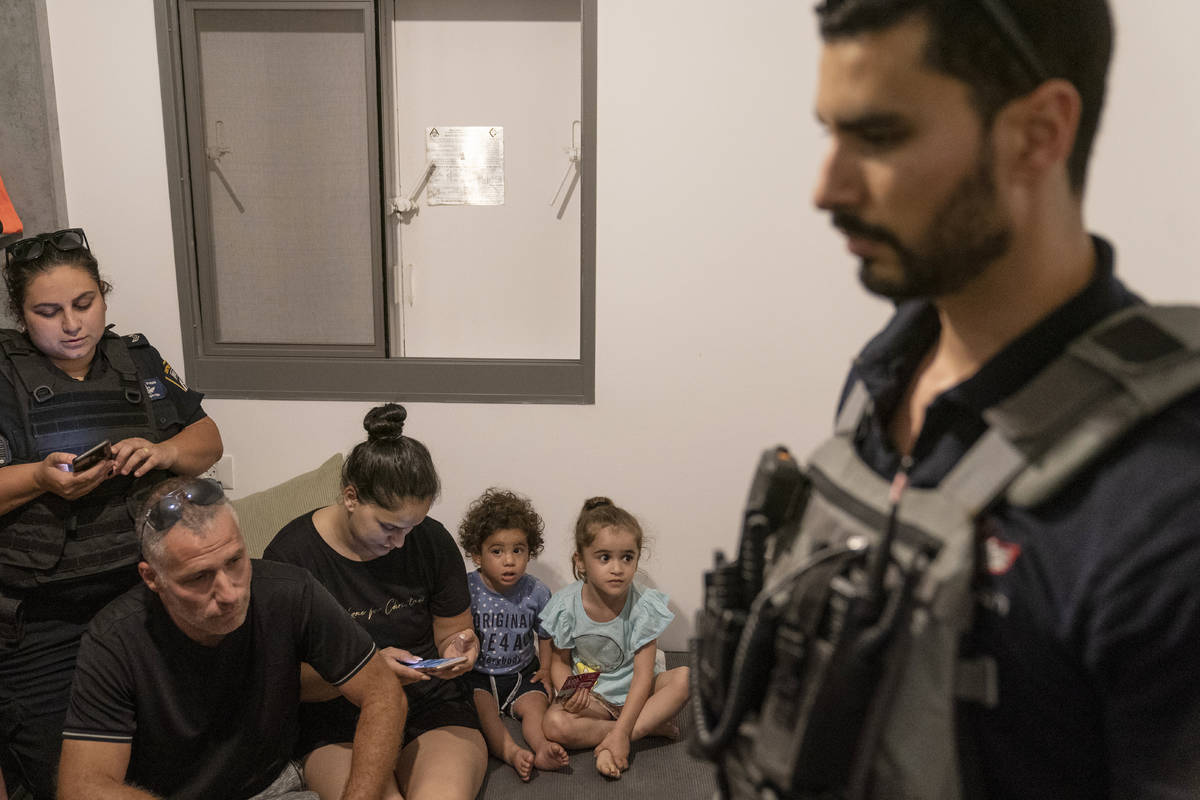 A family huddles in their home with bomb technicians and police as sirens warn of an incoming a ...