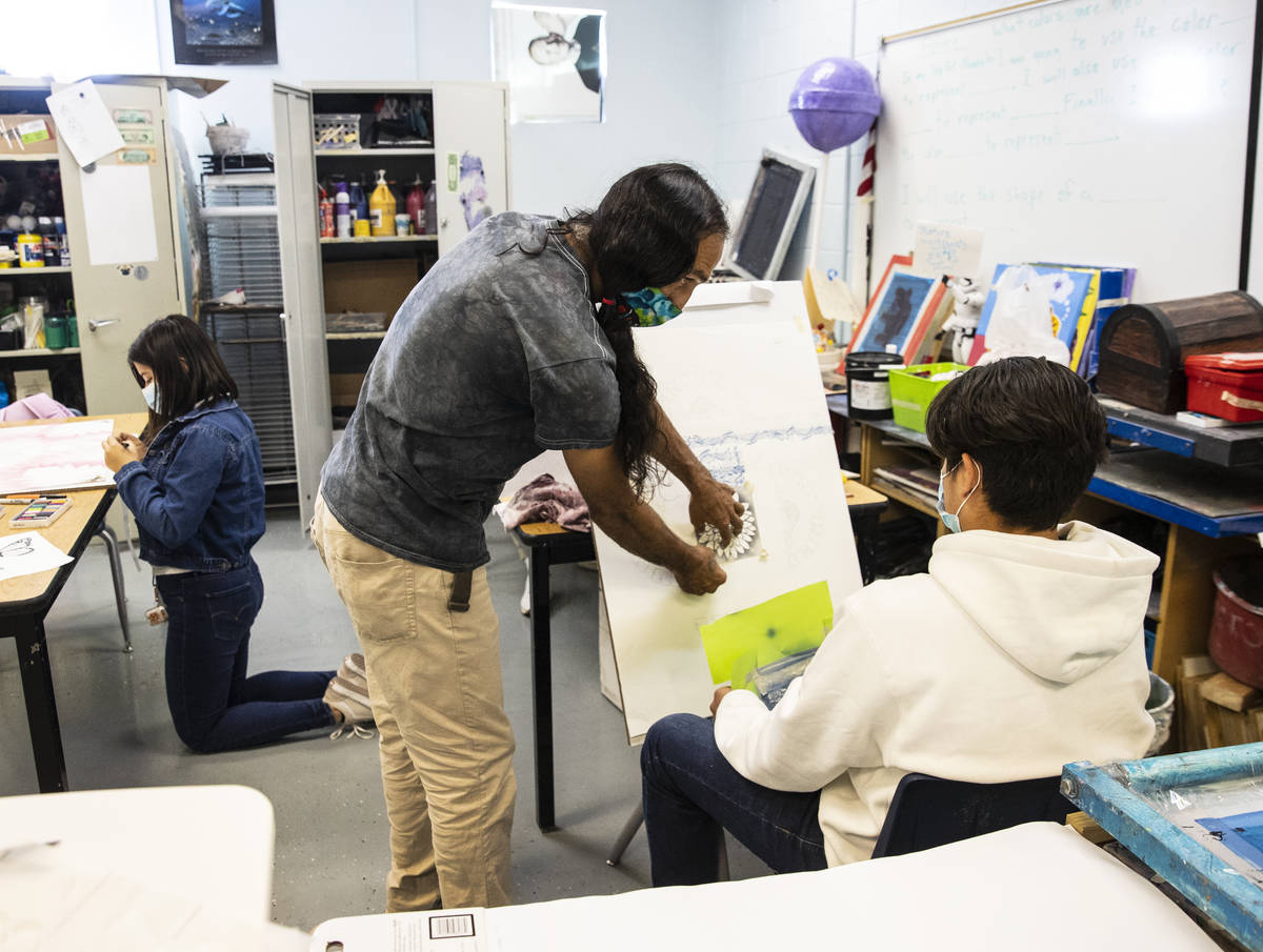 Global Community High School art teacher Antonio Cooper works with senior Edgar Avalos during a ...