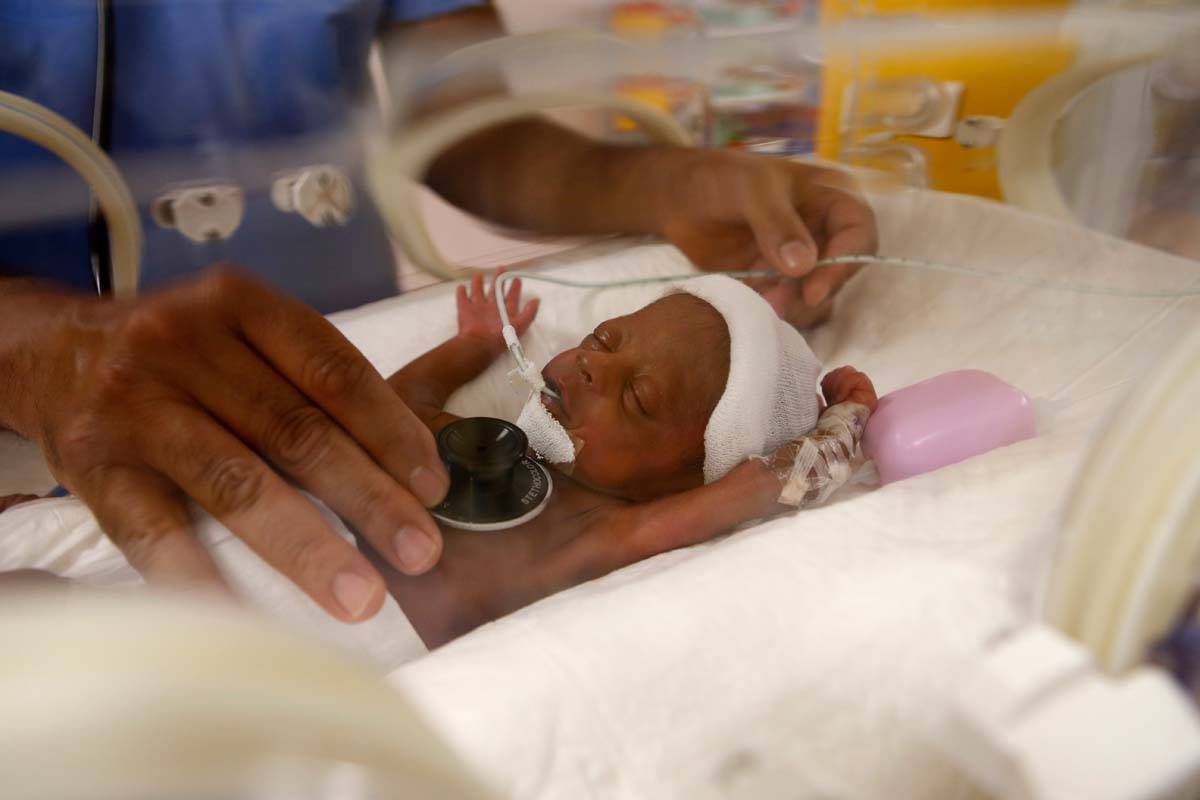 Paediatrician Dr. Msayif Khali examines with a stethoscope one of the nine babies protected in ...