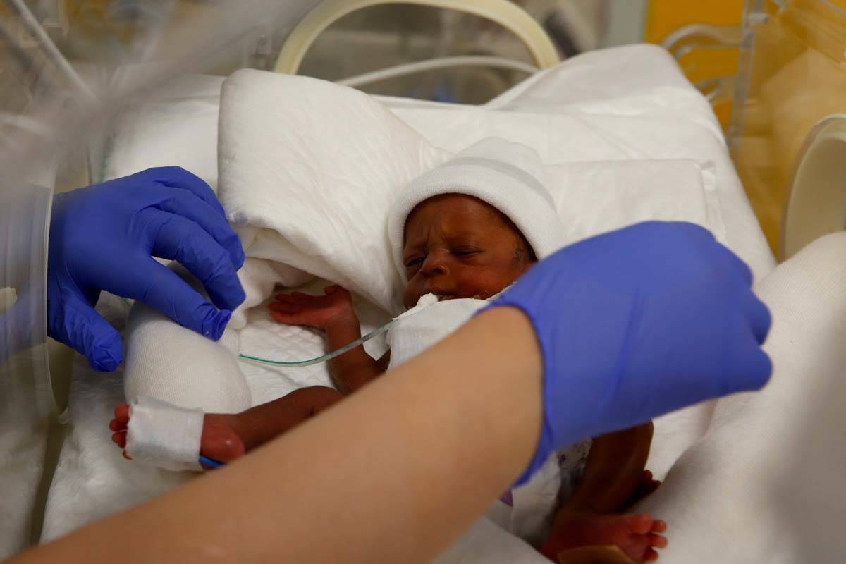 A nurse takes care of one of the nine babies protected in an incubator at the maternity unit of ...