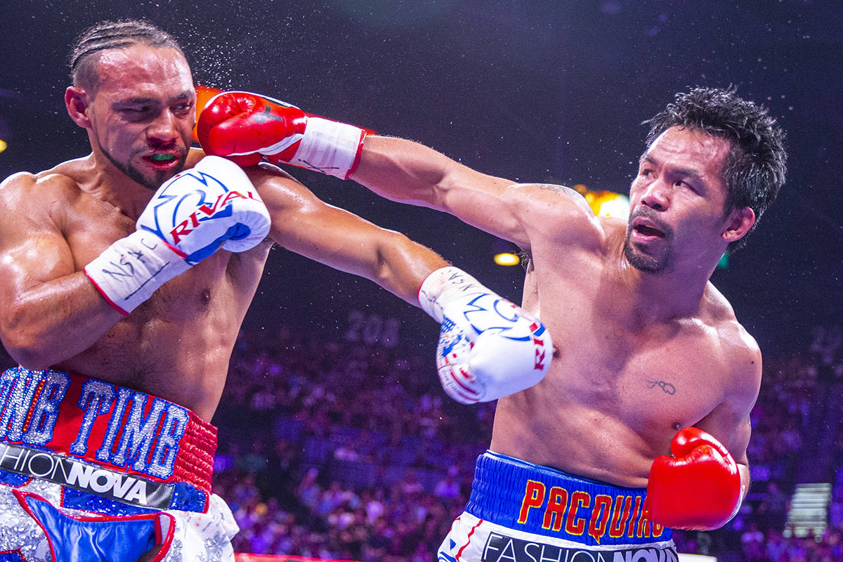 Keith Thurman is punched in the face by Manny Pacquiao during Round 5 of their WBA super welter ...