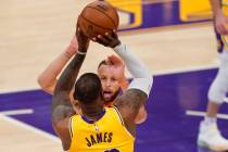 Los Angeles Lakers forward LeBron James, below, shoots and makes a three-point shot as Golden S ...