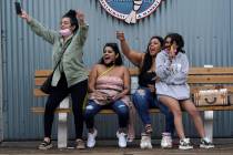 Visitors react after seeing a friend arrive on the pier in Santa Monica, Calif., on May 13, 202 ...