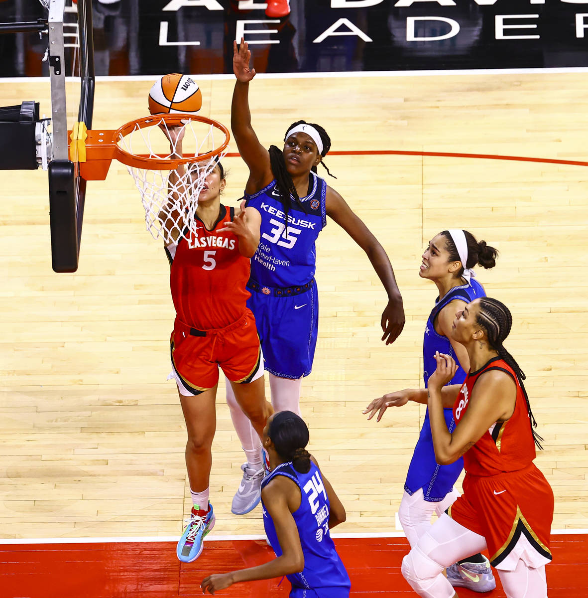 Las Vegas Aces' Dearica Hamby (5) goes to the basket under pressure from Connecticut Sun's Jonq ...