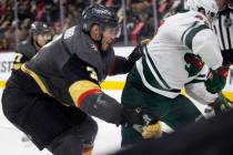 Golden Knights defenseman Brayden McNabb (3) slams Wild left wing Kevin Fiala (22) into the boa ...