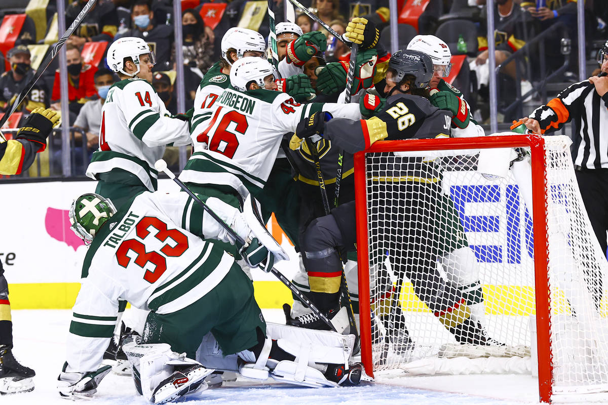 Minnesota Wild players go after Golden Knights' Mattias Janmark (26) during the second period o ...