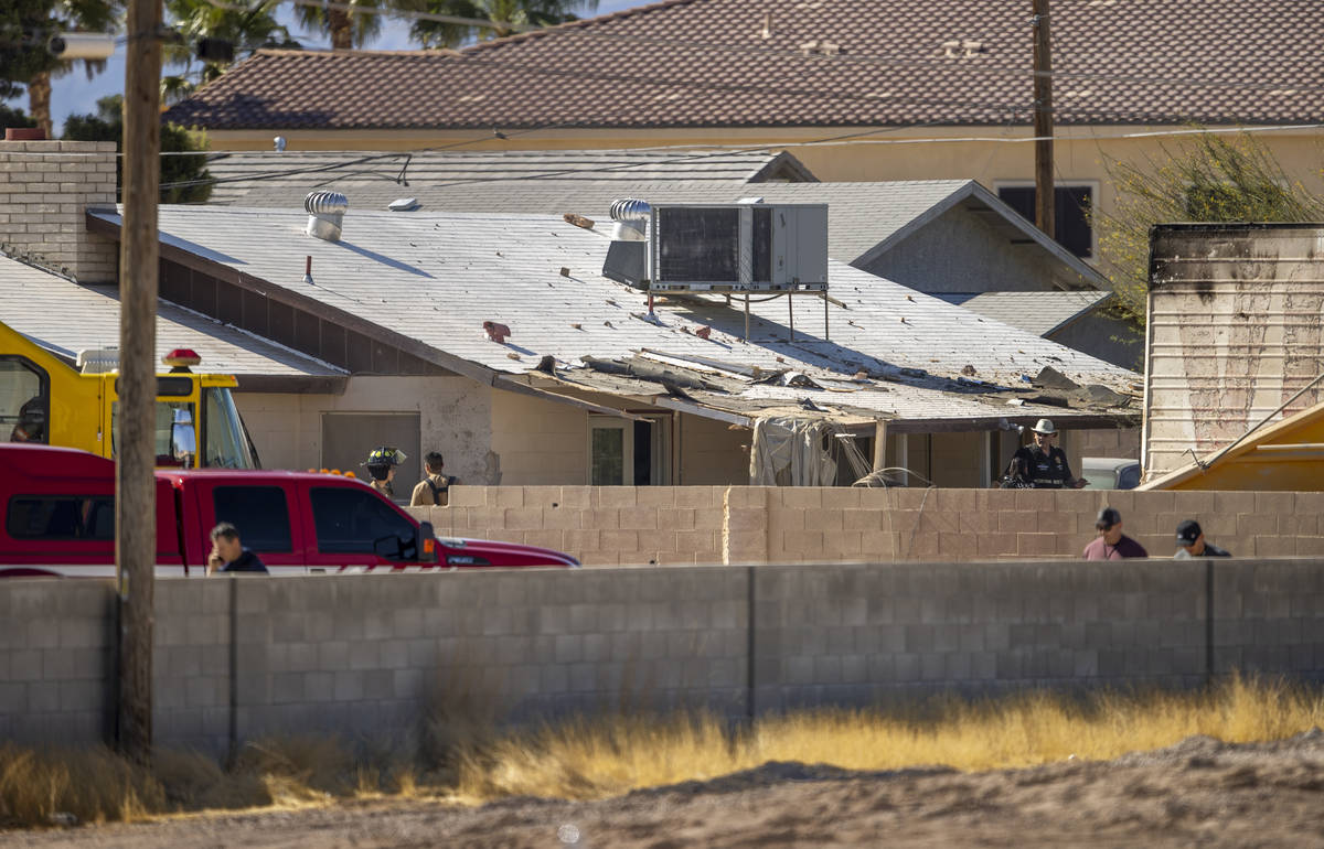 Firefighters and military personnel join neighbors near where a Nellis Air Force Base jet crash ...