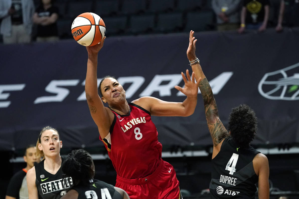 Las Vegas Aces' Liz Cambage (8) tries to get a shot off as Seattle Storm's Candice Dupree (4) d ...