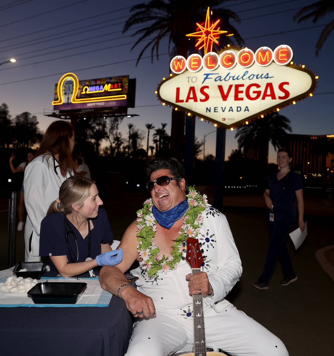 Elvis impersonator Mark Edward Rumpler receives a COVID-19 vaccine from Touro University Physic ...