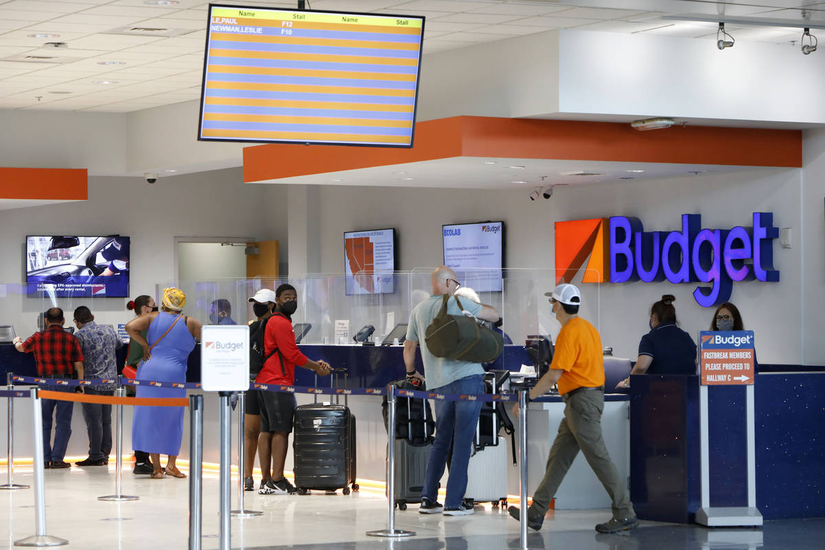 Travelers wait to get a rental car at a Budget car rental in the McCarran Rent-A-Car Center in ...
