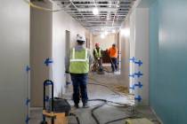 Construction workers smooth out a concrete floor at the under construction Josh Stevens Element ...