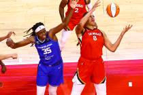 Las Vegas Aces' Liz Cambage (8) grabs a rebound in front of Connecticut Sun's Jonquel Jones (35 ...