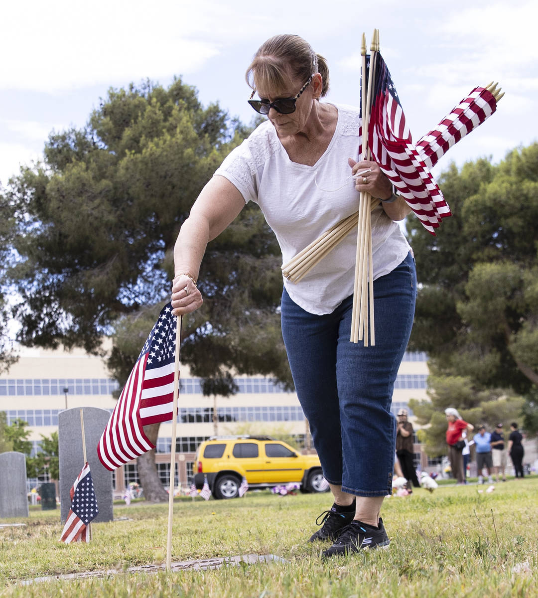 Lori Bordman, retired United States Air Force, placees American flags, in honor of Memorial Day ...