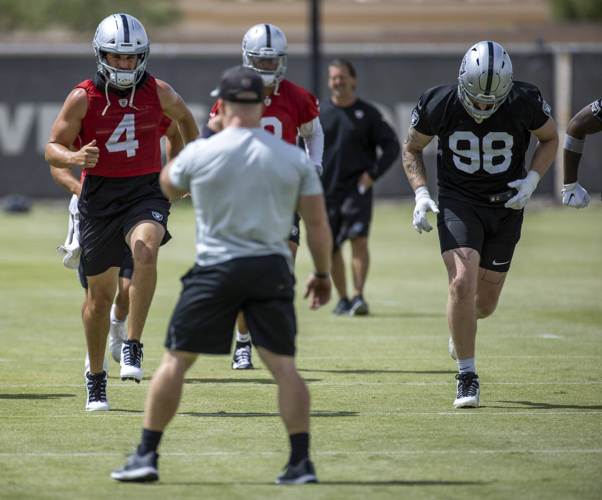 Quarterback Derek Carr (4) sprints with Nathan Peterman (3) and defensive end Maxx Crosby (98) ...