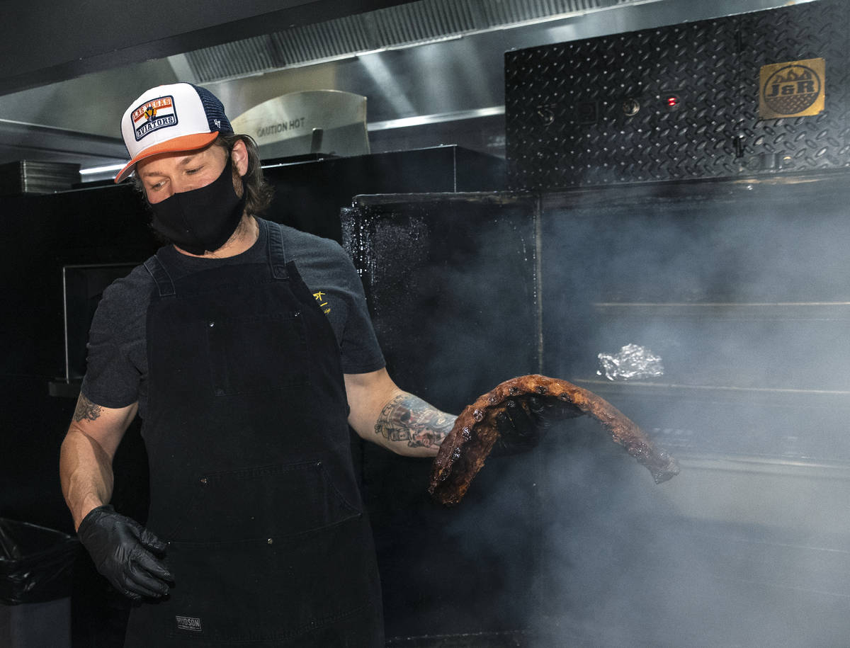 Joe Woodel, BBQ pitmaster, takes a rack of smoked pork ribs out of the smoker at The Beast by T ...