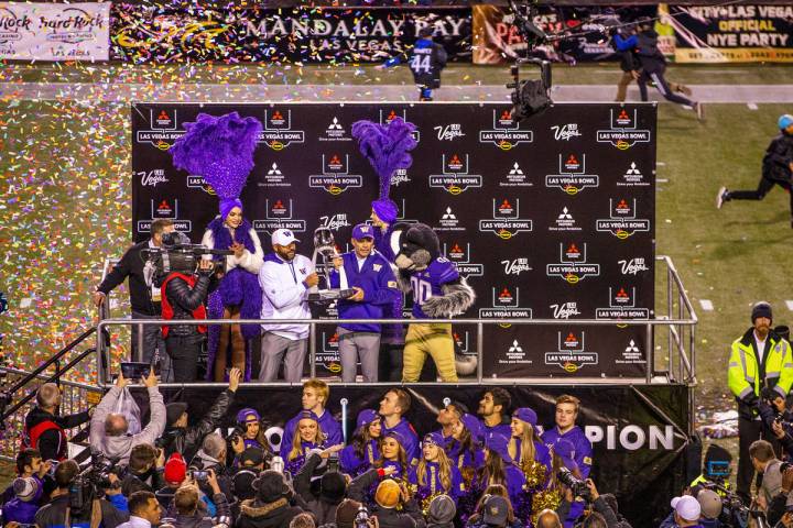 Washington Huskies head coach Chris Petersen, left center, and incoming head coach Jimmy Lake, ...