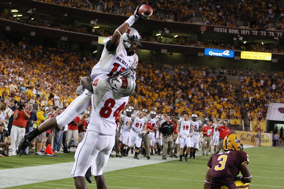 UNLV receiver Phillip Payne, top, celebrates with teammate Rodelin Anthony (84) after Payne bea ...