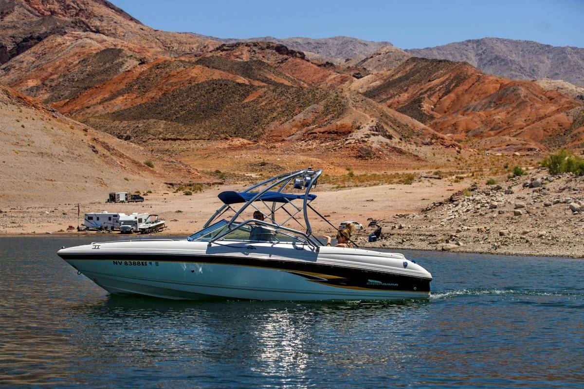 Boaters cruise past the Kingman Wash as campers are already set up for the holiday weekend with ...