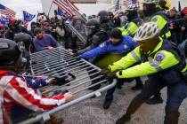 In this file photo from Wednesday Jan. 6, 2021, Trump supporters beset a police barrier at the ...