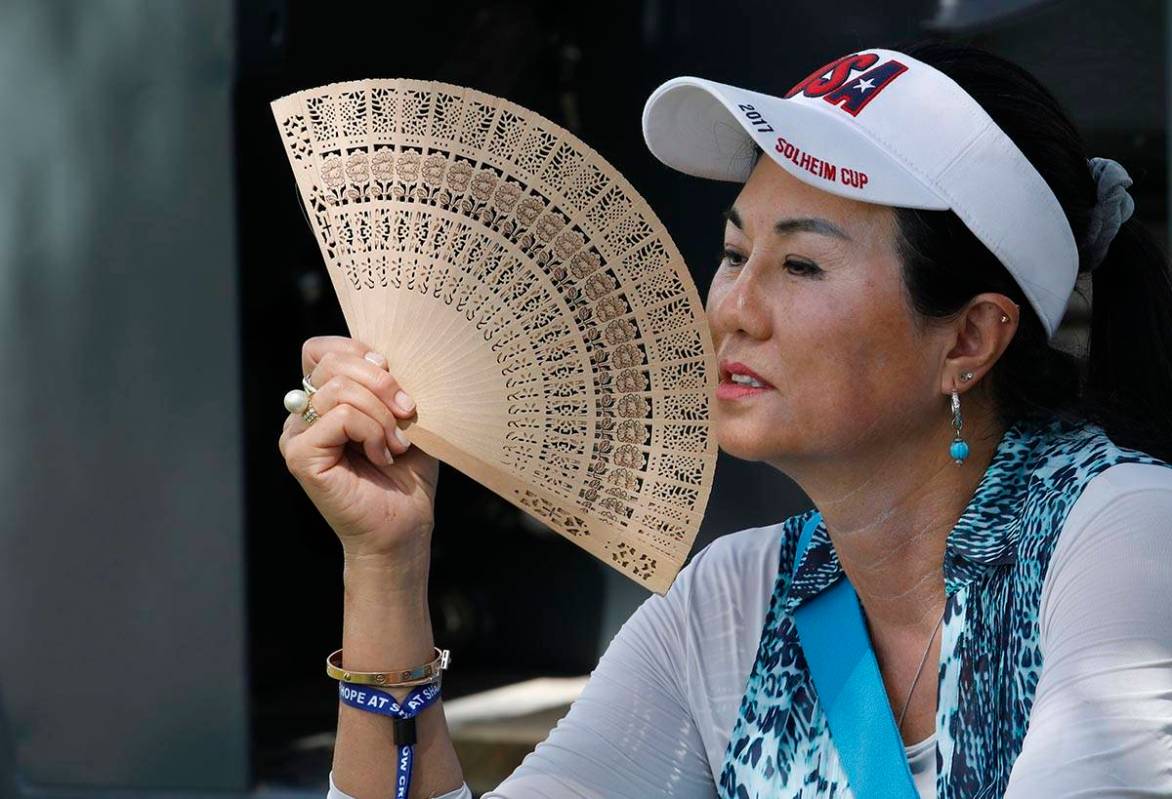Danielle Kang's mother, Grace Lee, uses a folding fan while waiting on the eighth green to see ...