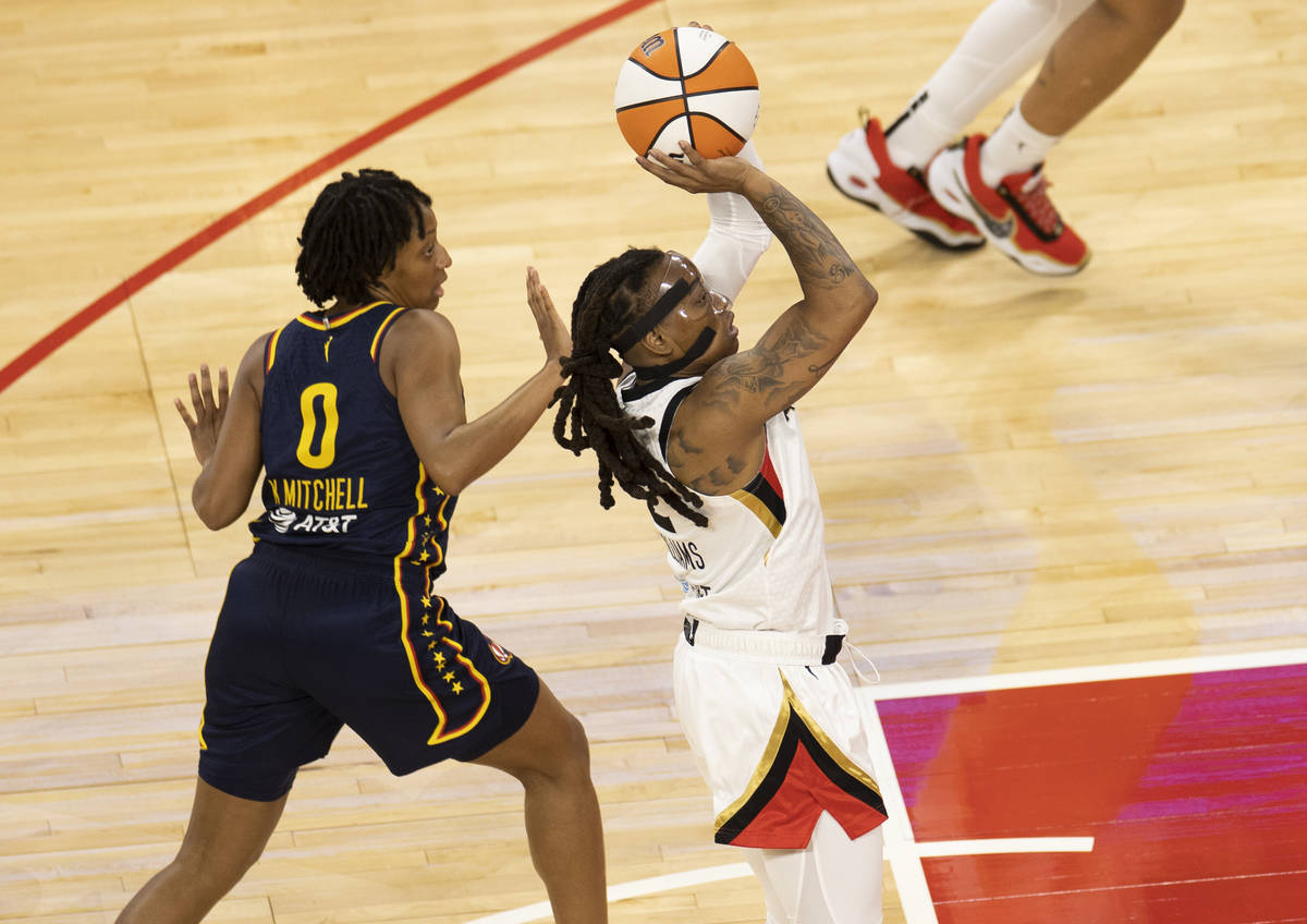 Las Vegas Aces forward Dearica Hamby (5) fights for a loose ball with Indiana Fever guard Victo ...