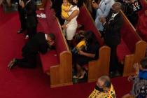 Rev. John R. Faison, Sr. kneels in prayer after preaching at a joint service for the centennial ...