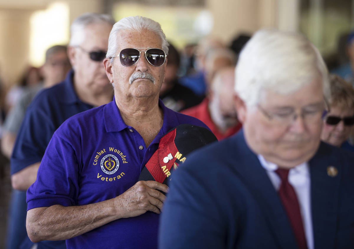 Vietnam veteran Mark Curley, left, stands during the playing of the national anthem during a Me ...