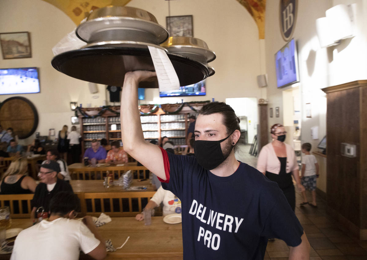 A server delivers food to a table during the grand reopening of Hofbrauhaus Las Vegas on Tuesda ...