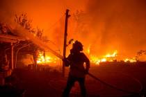 A firefighter works against the Lake Hughes Fire in Angeles National Forest north of Santa Clar ...
