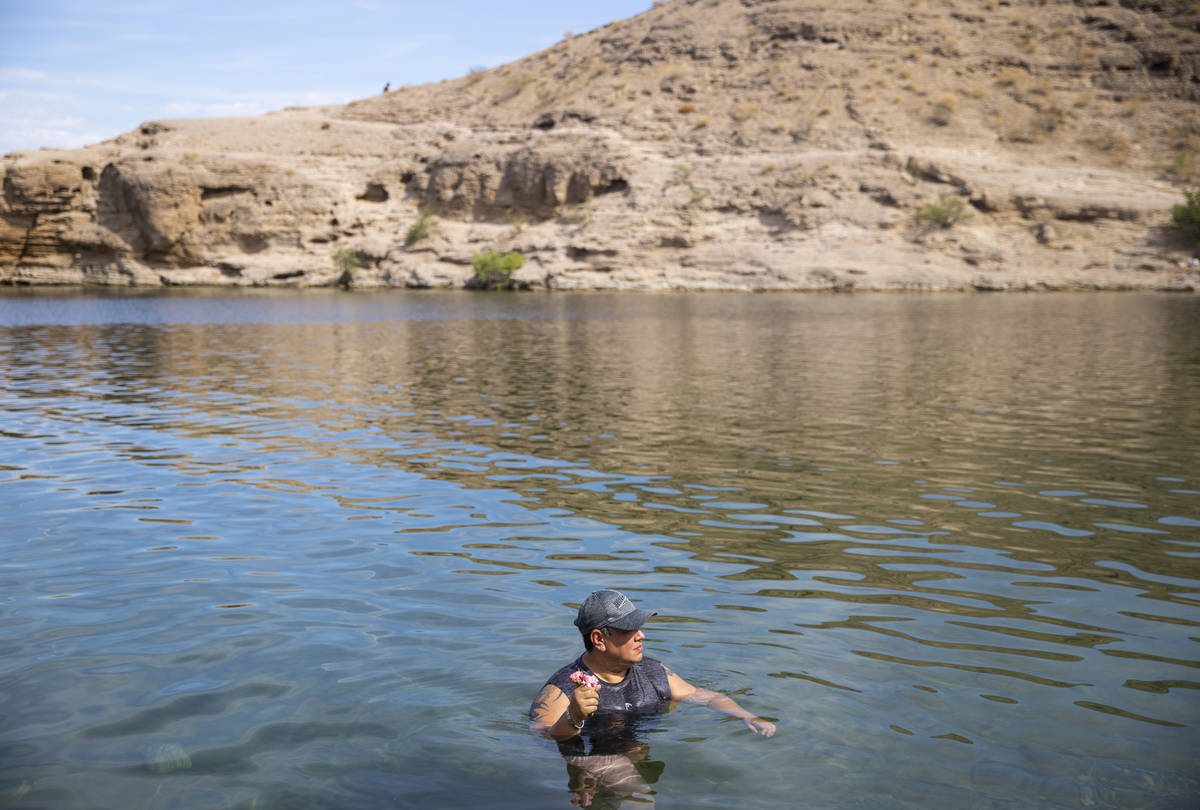 Rene Amador holds carnations before releasing them into the Colorado River at Nelson's Landing ...