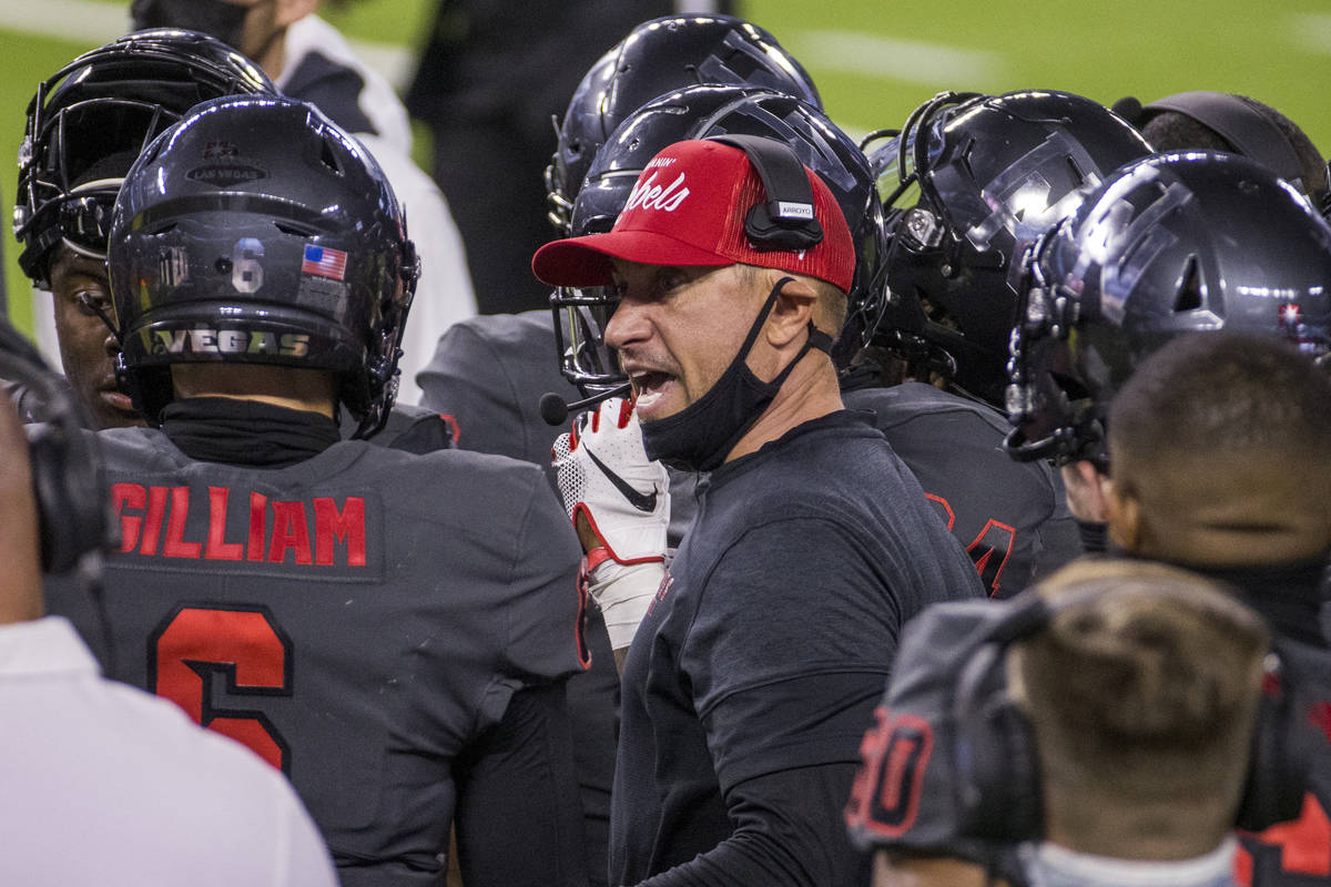 UNLV Rebels head coach Marcus Arroyo, center, speaks to quarterback Max Gilliam (6) and other ...