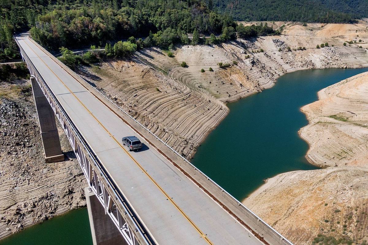 A car crosses Enterprise Bridge over Lake Oroville's dry banks Sunday, May 23, 2021, in Orovill ...