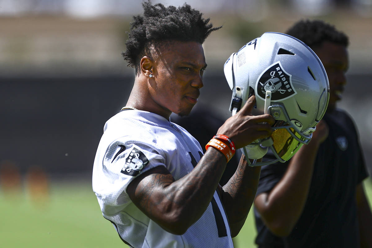 Raiders wide receiver Henry Ruggs III puts his helmet on during NFL football practice at Raider ...