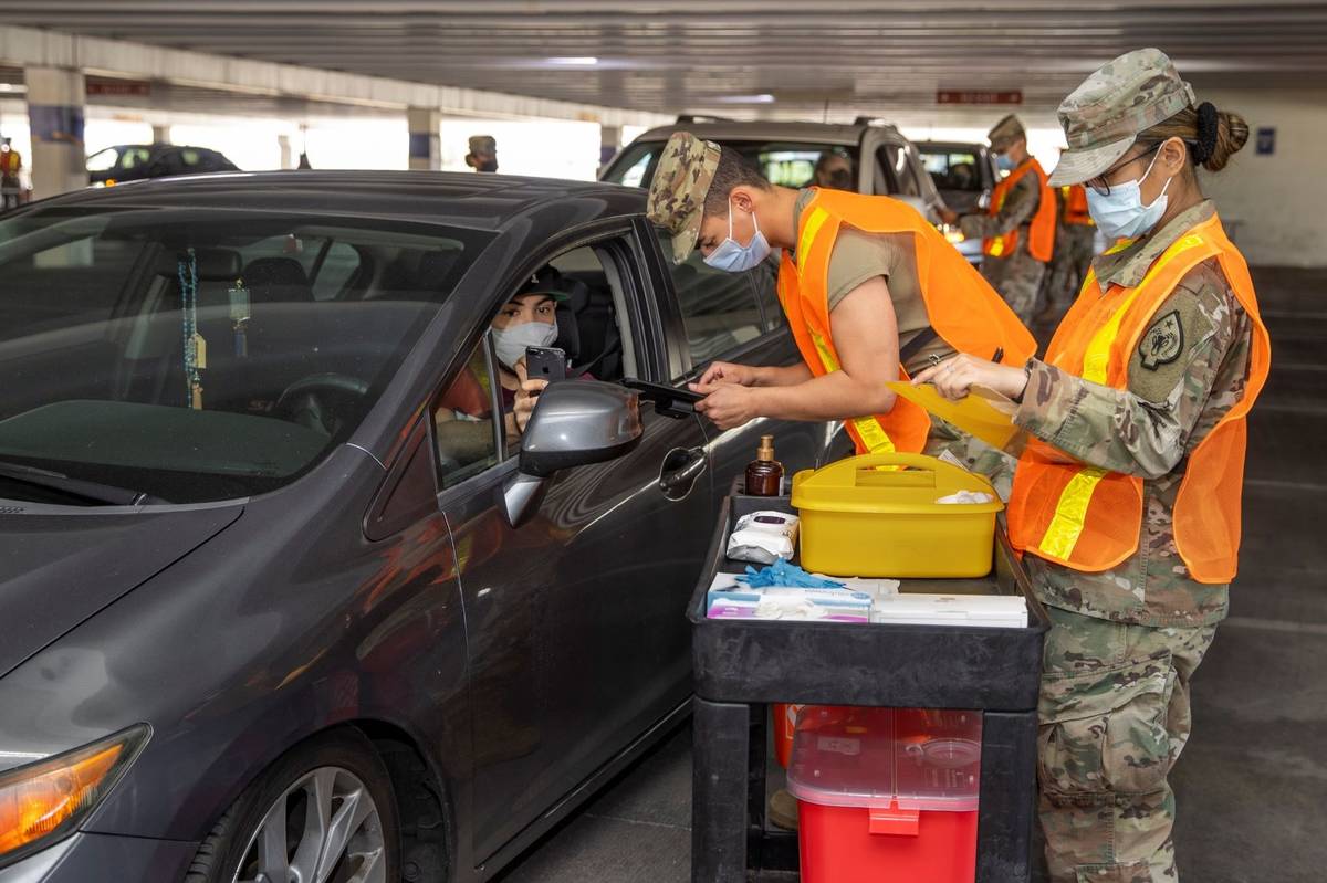 Andy Ruiz, left, looks on as Nevada National Guard SRA Dooley Gegen, center, gives him a shot d ...