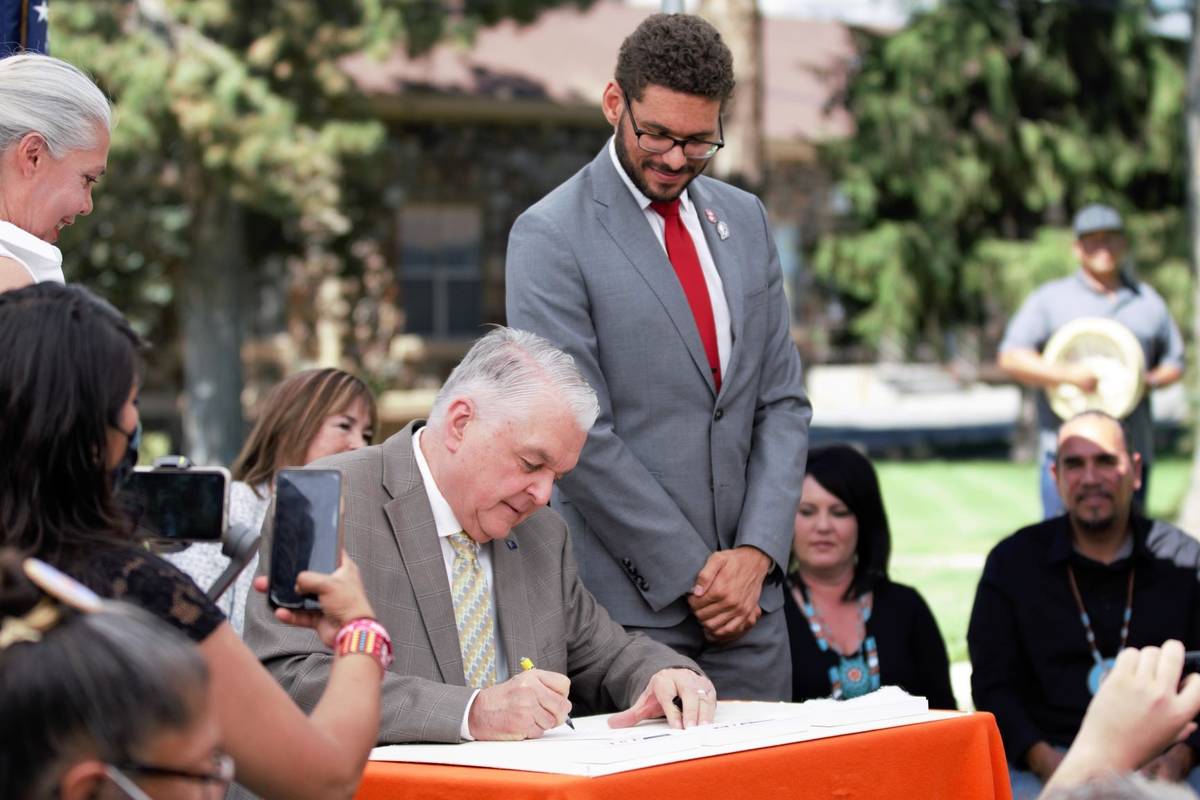 Gov. Steve Sisolak, left, signs Assembly Bill 88 which prohibits the use of racially discrimina ...