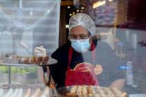 A worker wears a mask while prepares desserts at the Universal City Walk, in Universal City, Ca ...