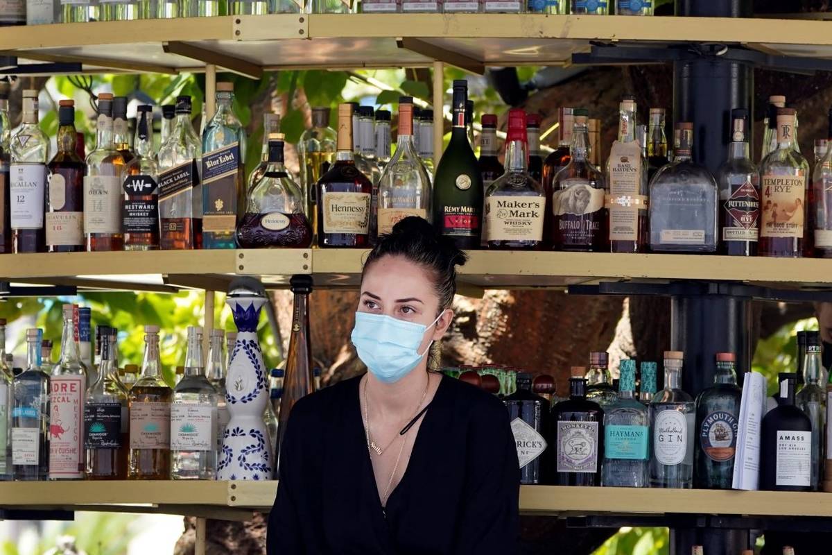 A bartender wears a mask while working at an outdoor bar amid the COVID-19 pandemic at The Grov ...