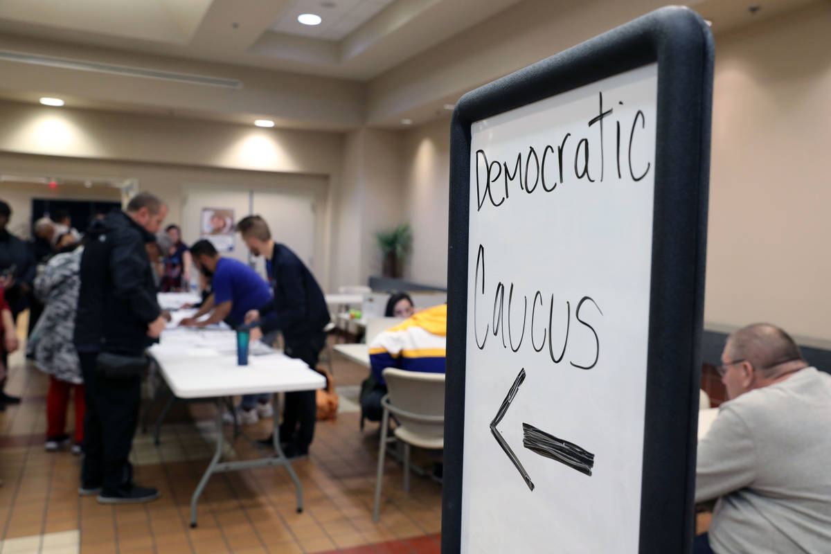 Individuals wait in line to register to caucus at the East Las Vegas Community Center in Las Ve ...