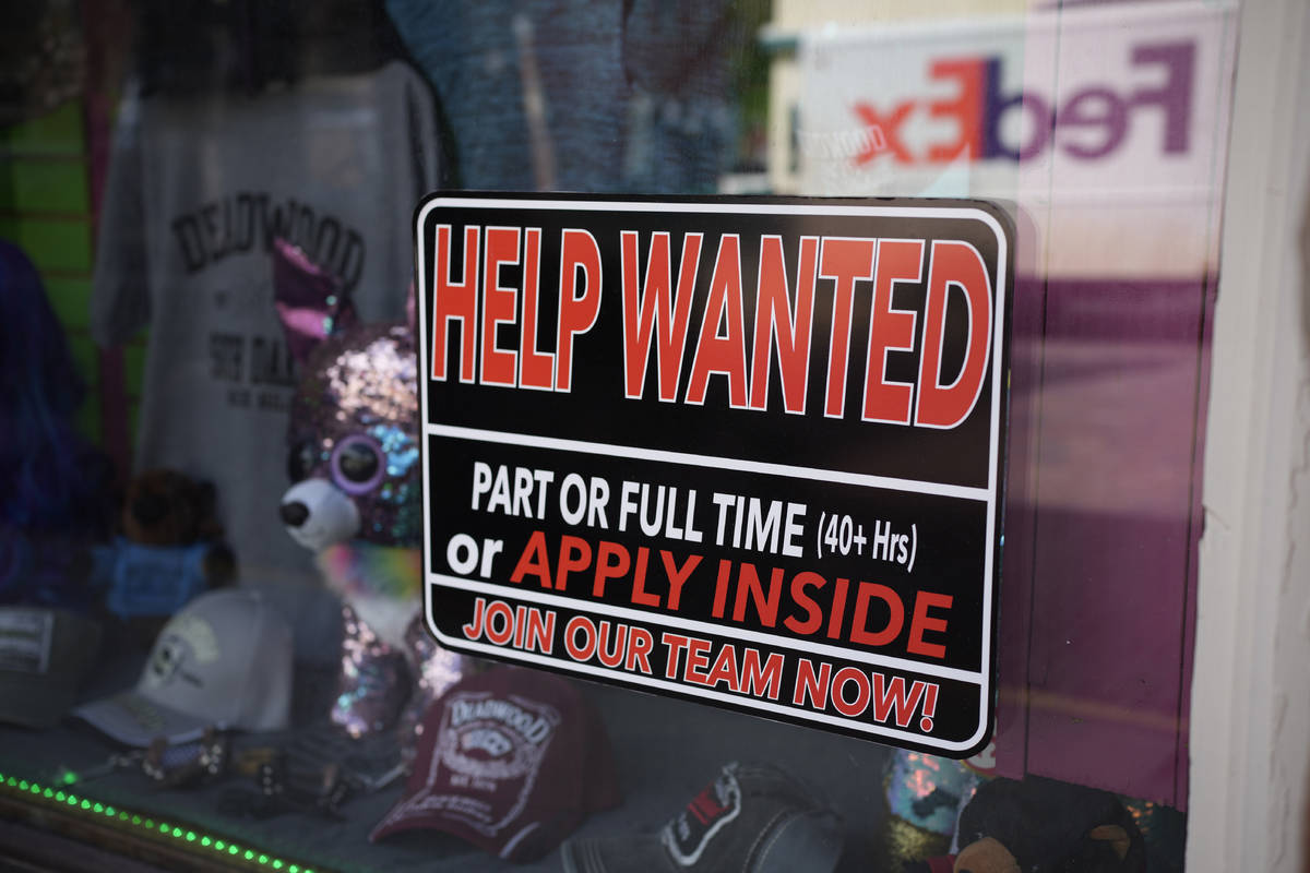 In this May 26, 2021 photo, a sign for workers hangs in the window of a shop along Main Street ...
