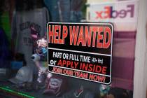 In this May 26, 2021 photo, a sign for workers hangs in the window of a shop along Main Street ...